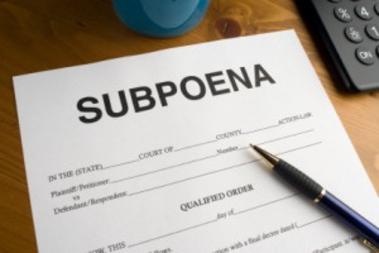 A closeup look at a form of subpoena with a pen on top