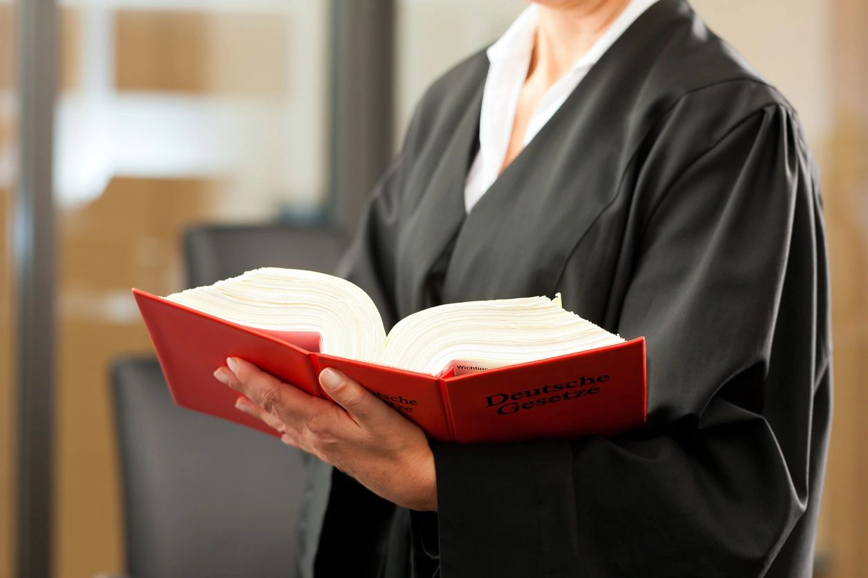 A lawyer holding a thick red legal book